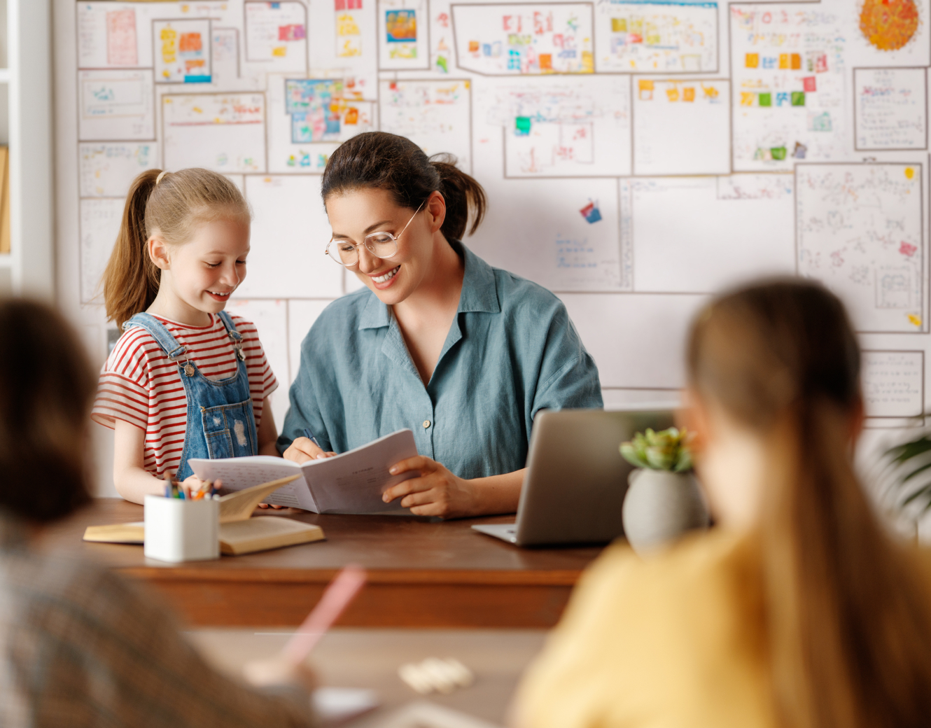 teacher helping young girl read